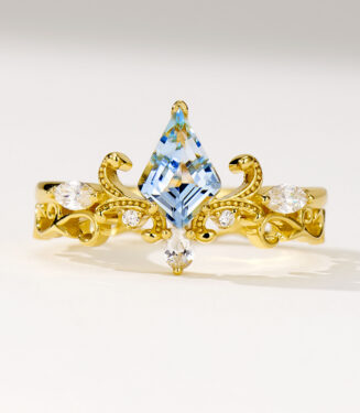Regal two-tone sterling silver ring featuring a large kite-cut light blue topaz stone at the center, surrounded by round brilliant-cut white cubic zirconia stones, set in an intricate gold-plated band with ornate scrollwork details, creating a majestic and eye-catching look perfect for adding a touch of royalty to any outfit.