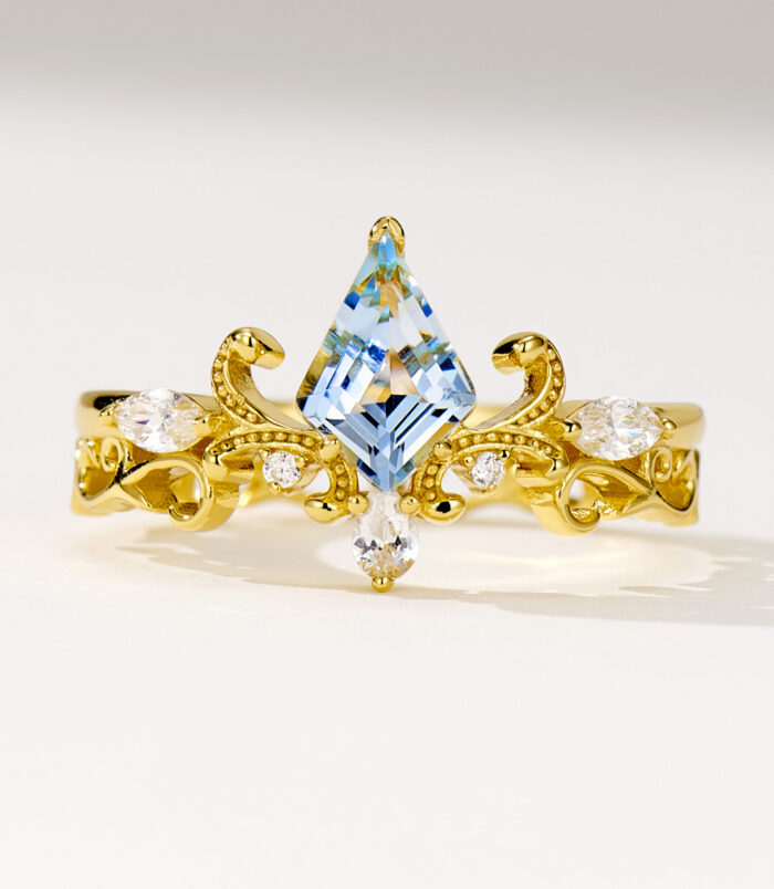 Regal two-tone sterling silver ring featuring a large kite-cut light blue topaz stone at the center, surrounded by round brilliant-cut white cubic zirconia stones, set in an intricate gold-plated band with ornate scrollwork details, creating a majestic and eye-catching look perfect for adding a touch of royalty to any outfit.