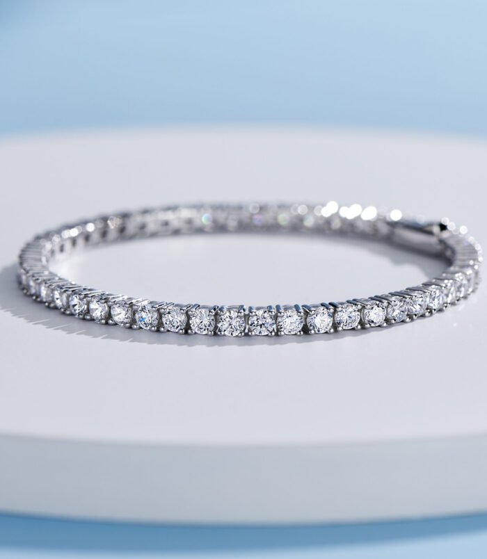 Classic tennis-style sterling silver bracelet with round brilliant-cut clear stones, polished finish.