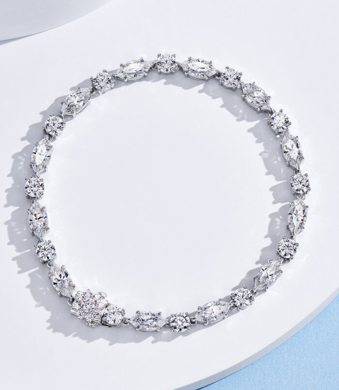 Multi-stone cluster design sterling silver bracelet with round clear stones, polished finish.