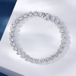 Heart-shaped cluster design sterling silver bracelet with clear stones, polished finish.