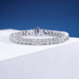 Single-row tennis-style sterling silver bracelet with round clear stones, polished finish.