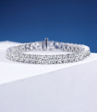 Single-row tennis-style sterling silver bracelet with round clear stones, polished finish.