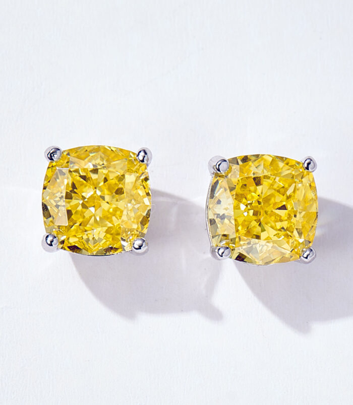 Vibrant Cushion-Cut Yellow zirconia Stud Earrings in Sterling Silver A pair of cushion-cut yellow diamond stud earrings in a four-prong sterling silver setting, displayed against a soft white background.