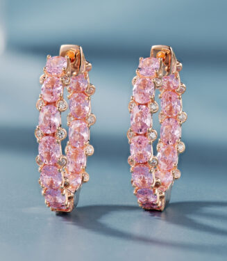 A pair of rose gold-toned hoop earrings adorned with oval-cut pink gemstones and small clear diamonds, set in polished sterling silver.