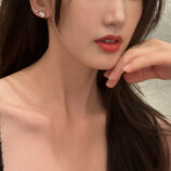 Classic Six-Prong Sterling Silver Stud Earrings displayed on a model's ear