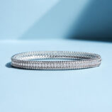 tennis-style sterling silver bracelet with round clear stones, polished finish.