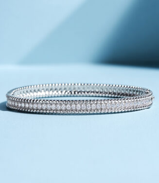 tennis-style sterling silver bracelet with round clear stones, polished finish.