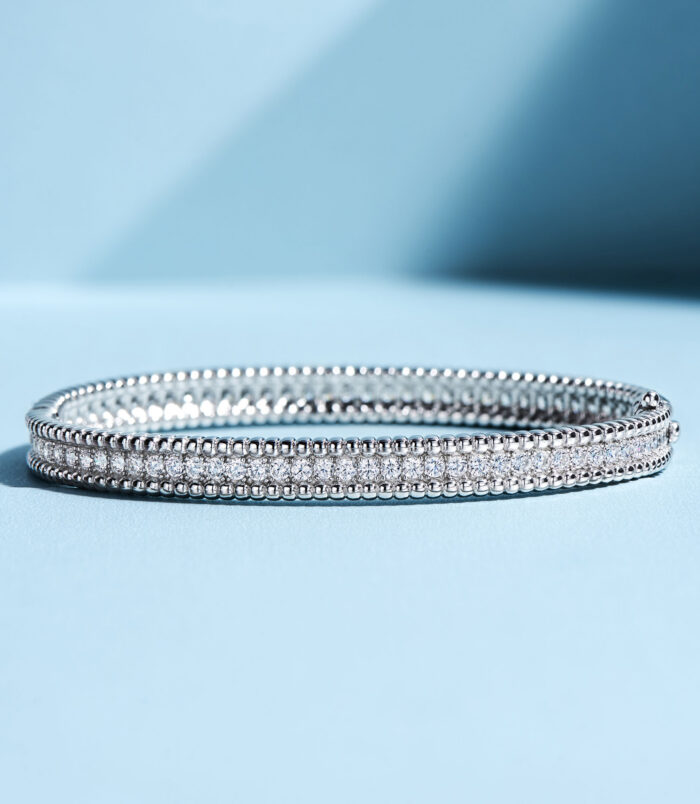 tennis-style sterling silver bracelet with round clear stones, polished finish.