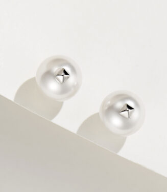 A pair of white pearl stud earrings with a small metallic star-shaped accent in the center, set in polished sterling silver.