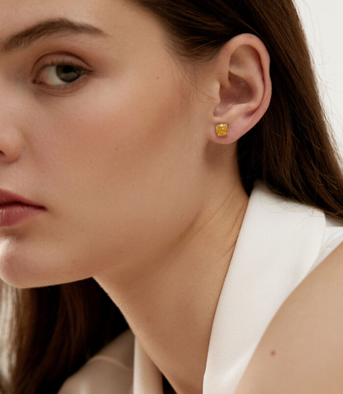 Vibrant Cushion-Cut Yellow zirconia Stud Earrings wearing effect Vibrant Cushion-Cut Yellow zirconia Stud Earrings worn on a model's ear