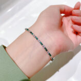 Alternating Green & Clear Stone Tennis-Style Sterling Silver Bracelet on a wrist