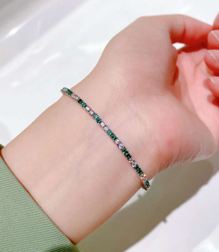 Alternating Green & Clear Stone Tennis-Style Sterling Silver Bracelet on a wrist