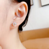 Four-Prong Sterling Silver Stud Earrings displayed on a model's ear