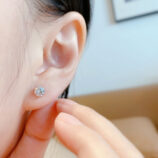 Four-Prong Sterling Silver Stud Earrings worn on a model's ear