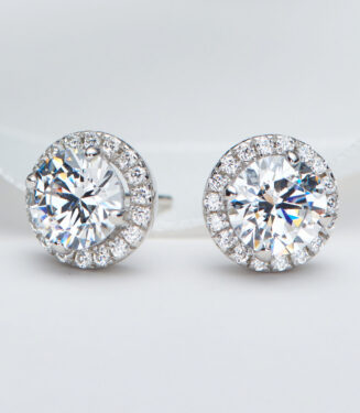 Sterling silver stud earrings with a round clear cubic zirconia center stone and halo setting.