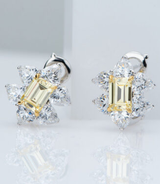 front side close up of Sterling silver stud earrings with a central yellow rectangular gemstone surrounded by clear cubic zirconia halo.