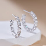 Sterling silver huggie hoop earrings with pavé-set clear cubic zirconia stones.