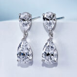 side view close up of Sterling silver drop earrings with pear-cut cubic zirconia stones in a polished silver setting.