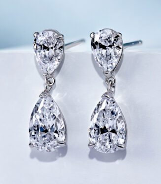 side view close up of Sterling silver drop earrings with pear-cut cubic zirconia stones in a polished silver setting.