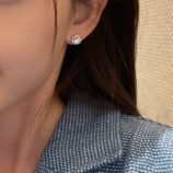 Sterling Silver Round-Cut Cubic Zirconia Halo Stud Earrings on model's ears