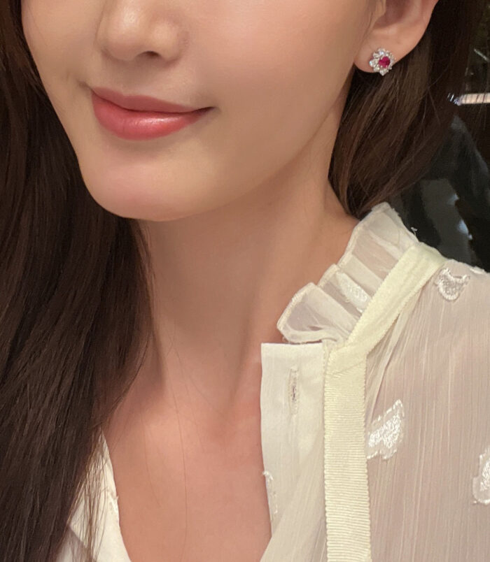 Sterling Silver red flower Halo Stud Earrings displayed on a model's ear