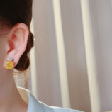 Sterling Silver Yellow Cushion-Cut Halo Stud Earrings display on a model's ear