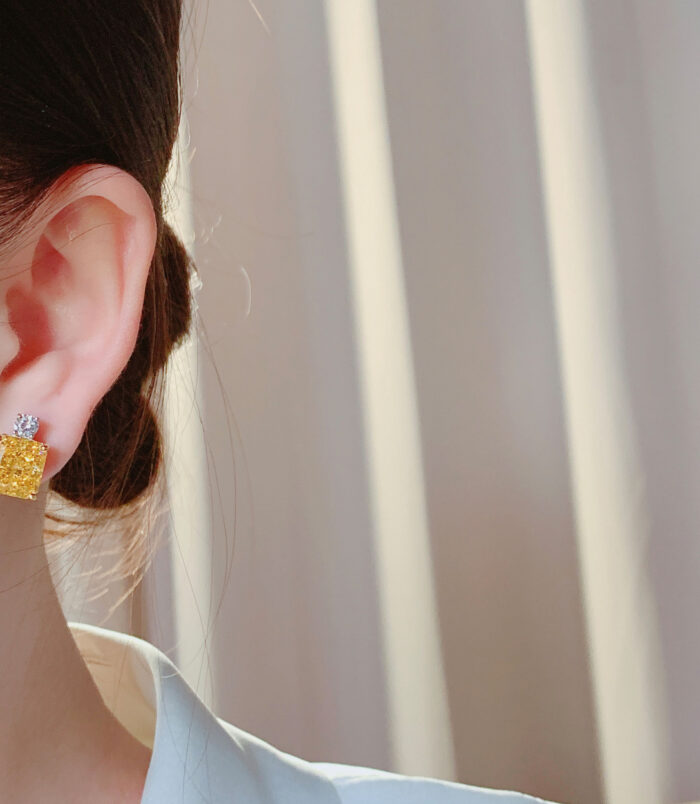 Sterling Silver Yellow Cushion-Cut Halo Stud Earrings display on a model's ear