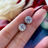 hand held close up of Sterling Silver Round-Cut Cubic Zirconia Halo Stud Earrings