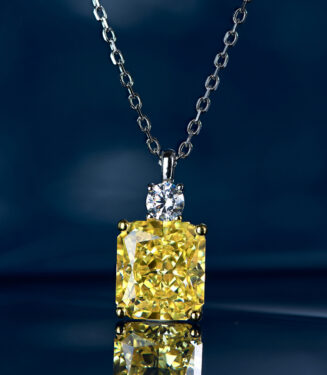 Stunning sterling silver necklace featuring a large cushion-cut yellow cubic zirconia stone as the centerpiece, secured in a four-prong setting, topped with a round brilliant-cut white cubic zirconia stone, paired with a classic cable chain, creating a luxurious and eye-catching look perfect for adding a touch of glamour to any outfit.