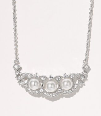 Elegant sterling silver necklace featuring a curved bar pendant adorned with three round white freshwater pearls, surrounded by a halo of round brilliant-cut white cubic zirconia stones, creating a sophisticated and timeless look perfect for adding a touch of classic elegance to any outfit.