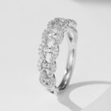 Elegant twisted infinity sterling silver ring featuring a continuous row of round brilliant-cut white cubic zirconia stones set in an intricate twisted band, creating a sparkling and sophisticated look perfect for adding a touch of glamour to any outfit.