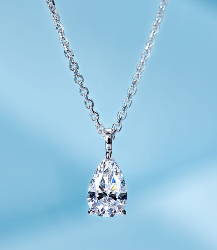 Elegant sterling silver solitaire necklace, showcasing a large pear-shaped brilliant-cut white cubic zirconia stone in a four-prong setting, paired with a classic cable chain, creating a timeless and sophisticated look perfect for adding a touch of luxury to any outfit.