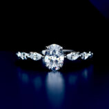 Exquisite sterling silver engagement ring featuring a large oval-cut cubic zirconia center stone in a four-prong setting, flanked by marquise-cut cubic zirconia accents along the polished band for a sophisticated and glamorous look.