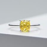 Elegant sterling silver ring featuring a large cushion-cut simulated yellow diamond center stone in a four-prong setting, paired with a sleek and simple band for a timeless and sophisticated look.