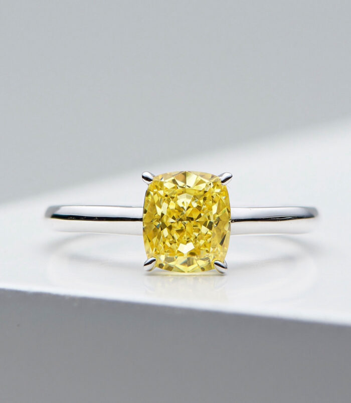 Timeless Cushion-Cut Yellow gemstone Sterling Silver Solitaire Ring Elegant sterling silver ring featuring a large cushion-cut simulated yellow diamond center stone in a four-prong setting, paired with a sleek and simple band for a timeless and sophisticated look.