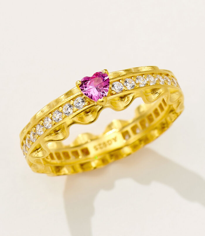 Romantic gold-plated sterling silver eternity ring featuring a central heart-shaped pink cubic zirconia stone flanked by round brilliant-cut white cubic zirconia stones set in a scalloped band, creating a feminine and elegant look perfect for expressing love and affection.