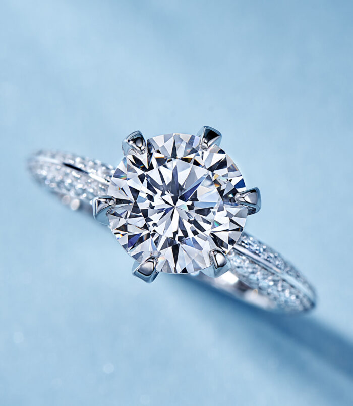 Classic solitaire sterling silver ring with a large round brilliant-cut cubic zirconia center stone, set in a six-prong setting, and accented with smaller pavé-set zircons along the band for timeless elegance.