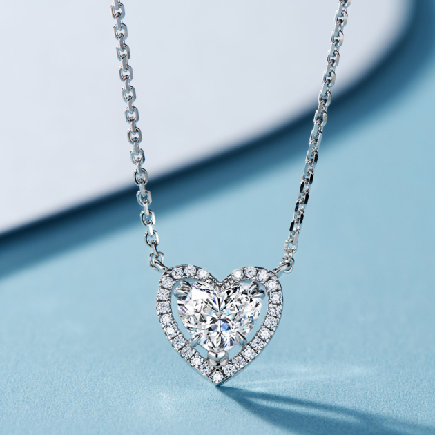 Romantic sterling silver heart-shaped pendant necklace, featuring a large heart-shaped brilliant-cut white cubic zirconia stone as the centerpiece, surrounded by a halo of small round brilliant-cut white cubic zirconia stones, paired with a classic cable chain, creating a timeless and elegant look perfect for expressing love and adding a touch of romance to any outfit.