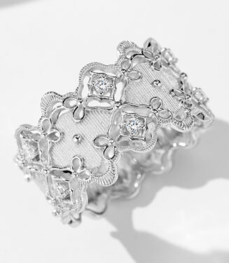 Intricate vintage-inspired sterling silver band ring featuring an openwork floral design with delicate milgrain detailing, round brilliant-cut cubic zirconia accents, and a textured brushed silver center, creating a romantic and sophisticated look perfect for adding a touch of vintage charm to any outfit.