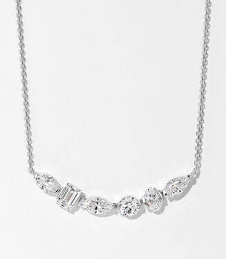 Elegant sterling silver smile necklace, featuring a row of mixed-cut white cubic zirconia stones including emerald-cut, round brilliant-cut, and marquise-cut stones, set in a sleek bar design, paired with a classic cable chain, creating a sophisticated and modern look perfect for adding a touch of luxury to any outfit.