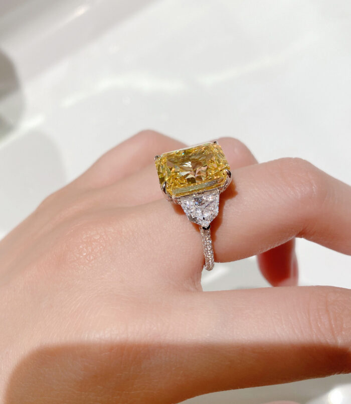 side view close-up of Luxury Yellow Emerald-Cut Three-Stone Sterling Silver Ring on model's finger