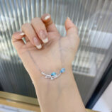 hand held close-up of Sterling Silver Blue Zirconia Stones and Star Accents Necklace