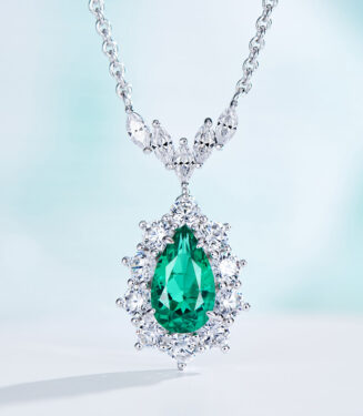 Exquisite sterling silver necklace featuring a large pear-cut green cubic zirconia stone at the center, surrounded by a halo of round brilliant-cut white cubic zirconia stones, topped with a decorative bail adorned with marquise-cut white cubic zirconia stones, creating a dazzling and sophisticated look perfect for adding a touch of elegance to any outfit.