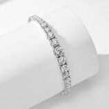 side view of gradient Tennis 925 Silver Bracelet , The design emphasizes the size of the stones, with the middle stone being larger than the two smaller ones on either side.