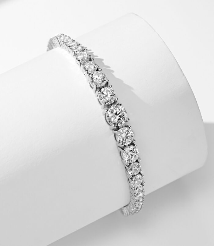 side view of gradient Tennis 925 Silver Bracelet , The design emphasizes the size of the stones, with the middle stone being larger than the two smaller ones on either side.