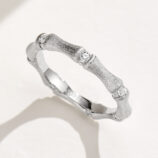 Unique bamboo-inspired sterling silver ring with textured segments and round brilliant-cut cubic zirconia accents, symbolizing resilience, growth, and prosperity, perfect for nature lovers and those who appreciate meaningful jewelry.