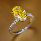 Stunning sterling silver ring featuring a large oval-cut yellow gemstone centerpiece, accented with sparkling cubic zirconia along the band for a luxurious look.