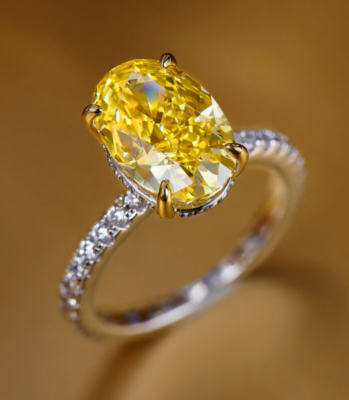 Stunning sterling silver ring featuring a large oval-cut yellow gemstone centerpiece, accented with sparkling cubic zirconia along the band for a luxurious look.