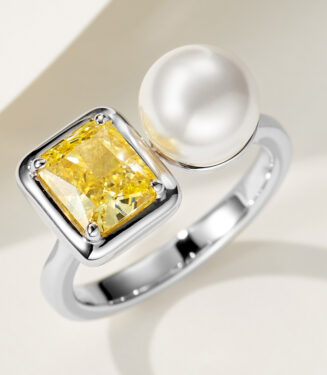 Modern two-stone open sterling silver ring featuring a large emerald-cut yellow cubic zirconia stone set in a bezel setting and a lustrous white pearl, creating a bold and contemporary look perfect for adding a touch of luxury to any outfit.
